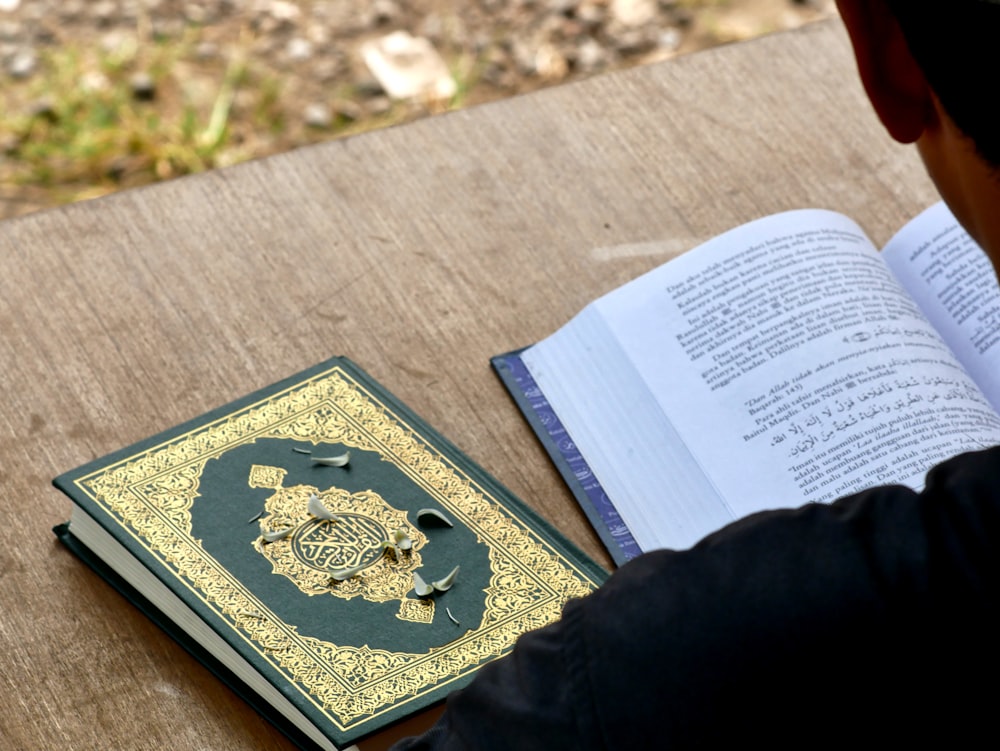 a person sitting at a table reading a book