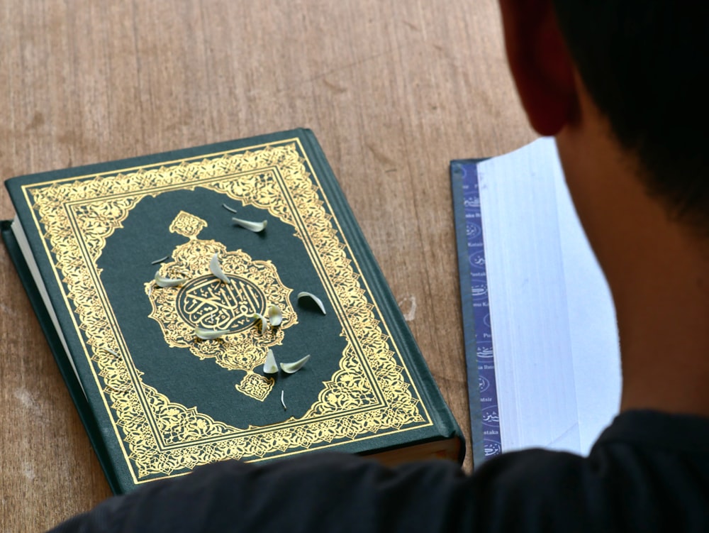 a man looking at a book on a table