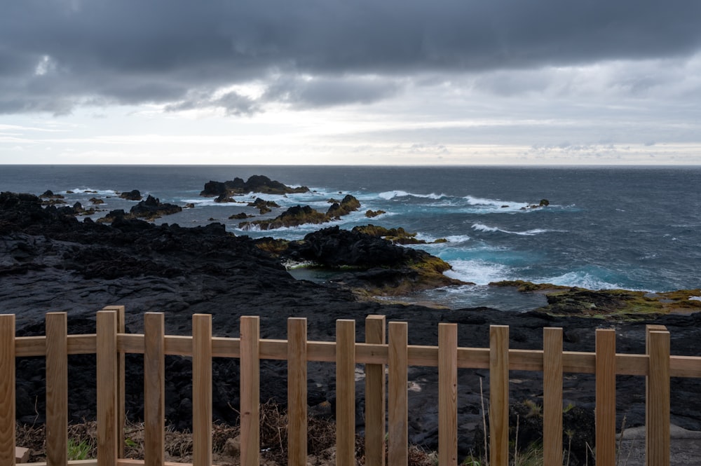 a wooden fence next to a body of water