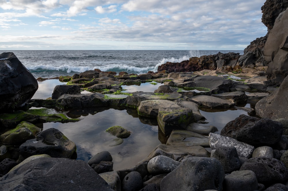 a rocky beach with a body of water in the distance