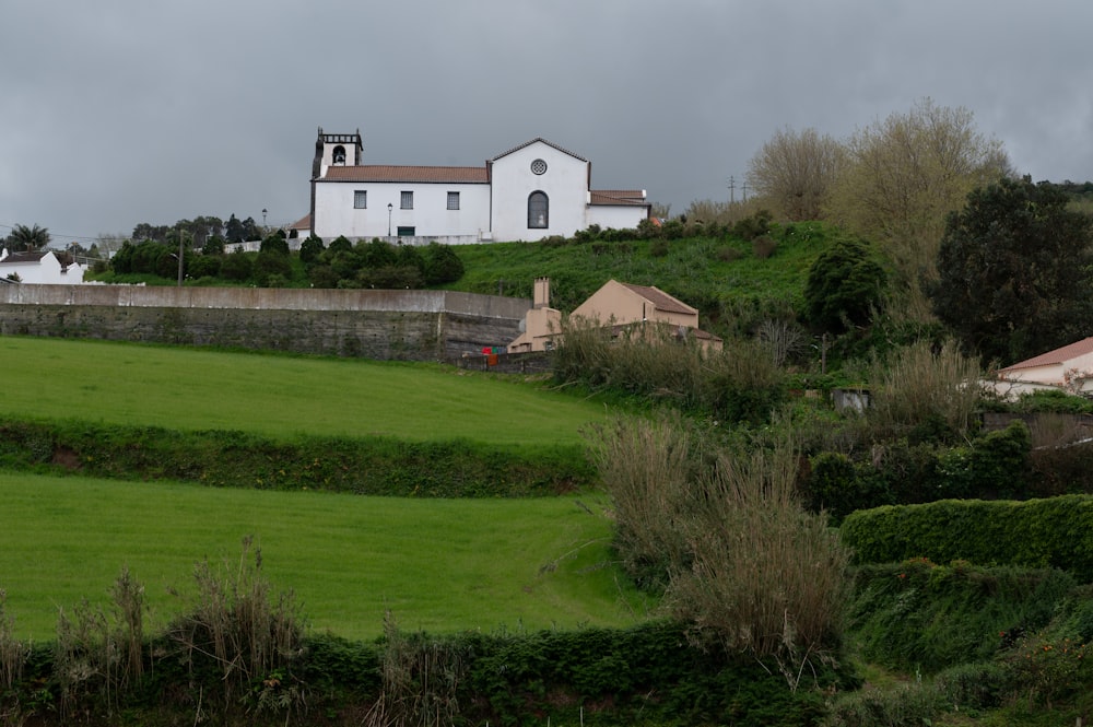 a house on a hill with a church in the background