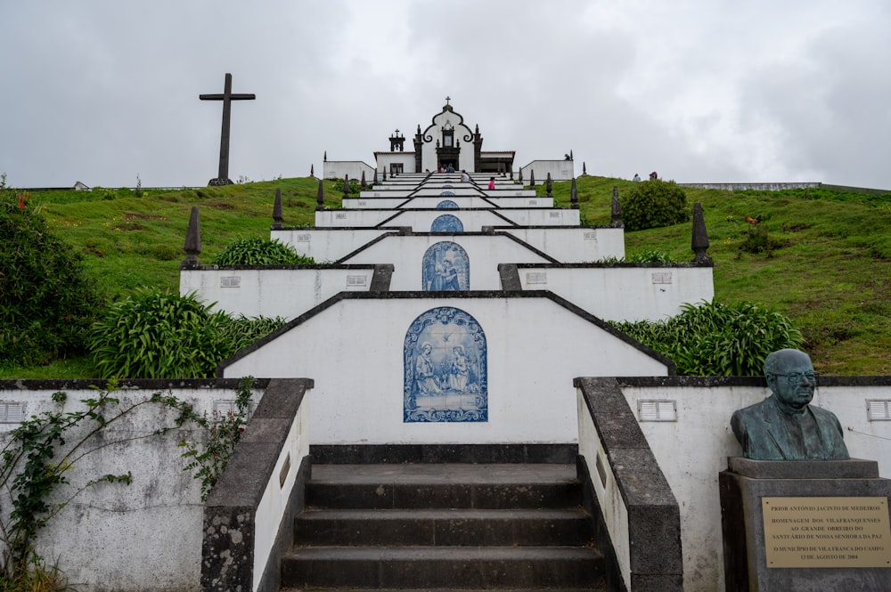 a statue of a man sitting on top of a set of stairs