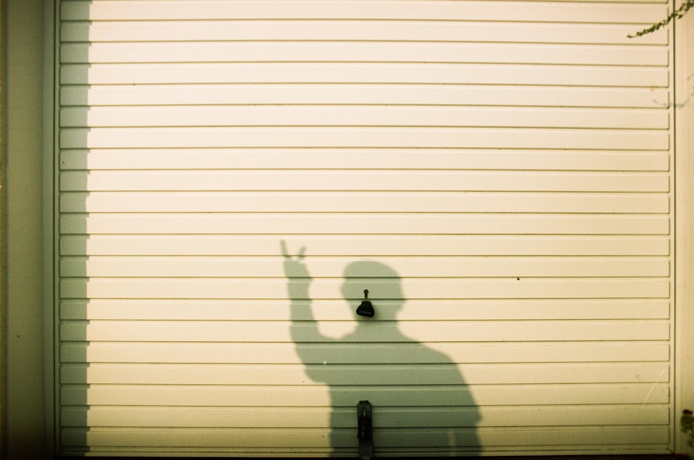 a shadow of a person standing in front of a garage door