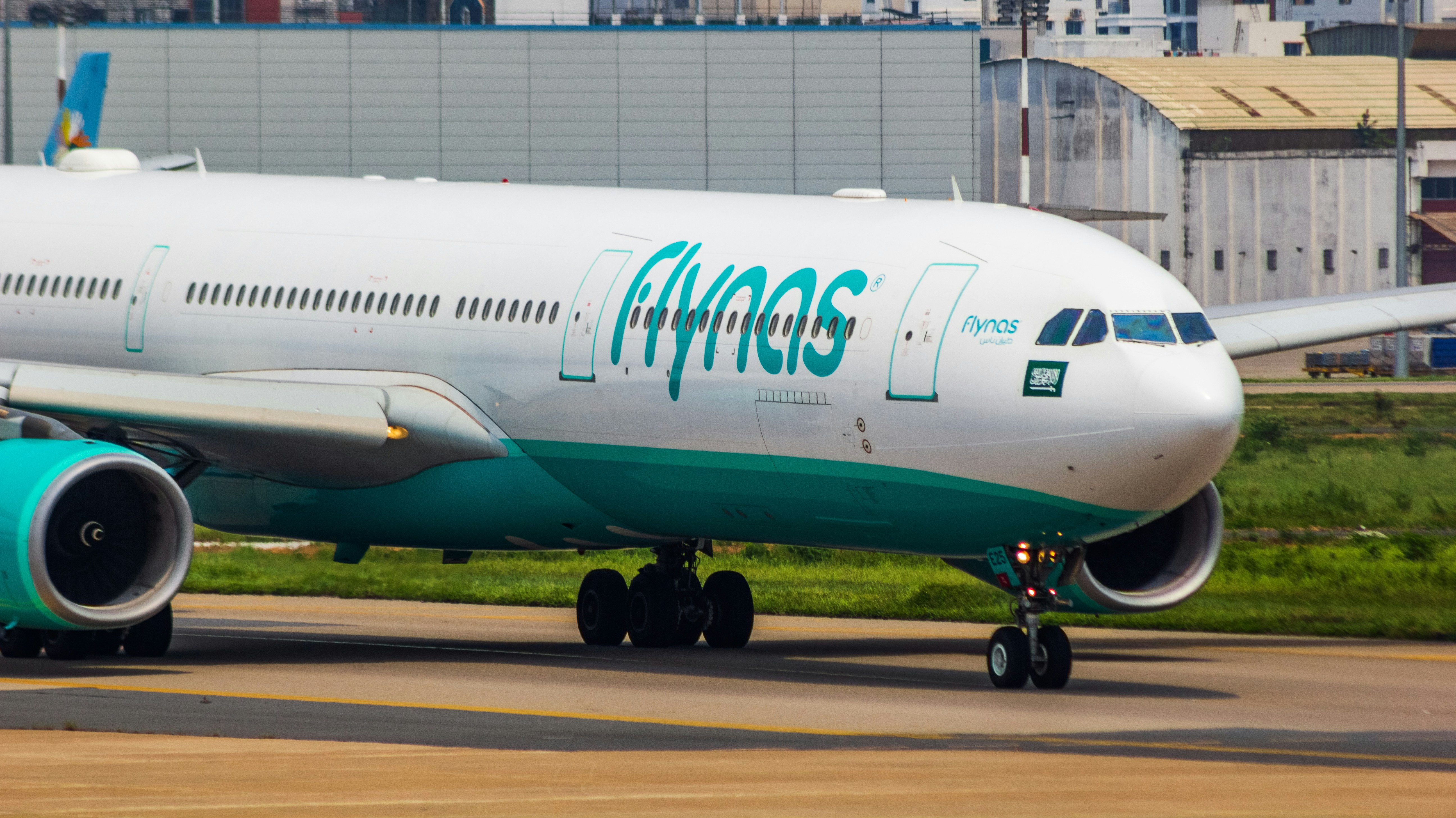 a large passenger jet sitting on top of an airport runway, flynas A330 aircraft closeup