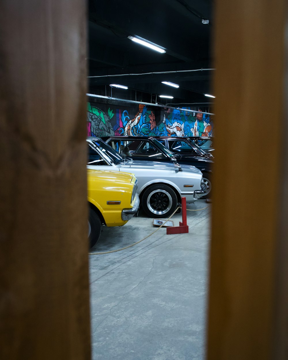 a yellow car parked in a garage next to other cars