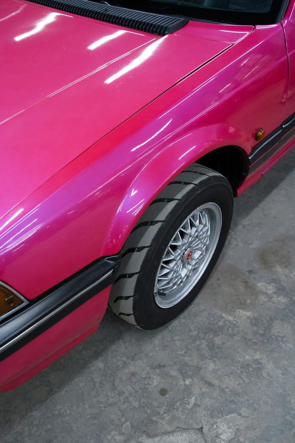 a pink car is parked in a garage