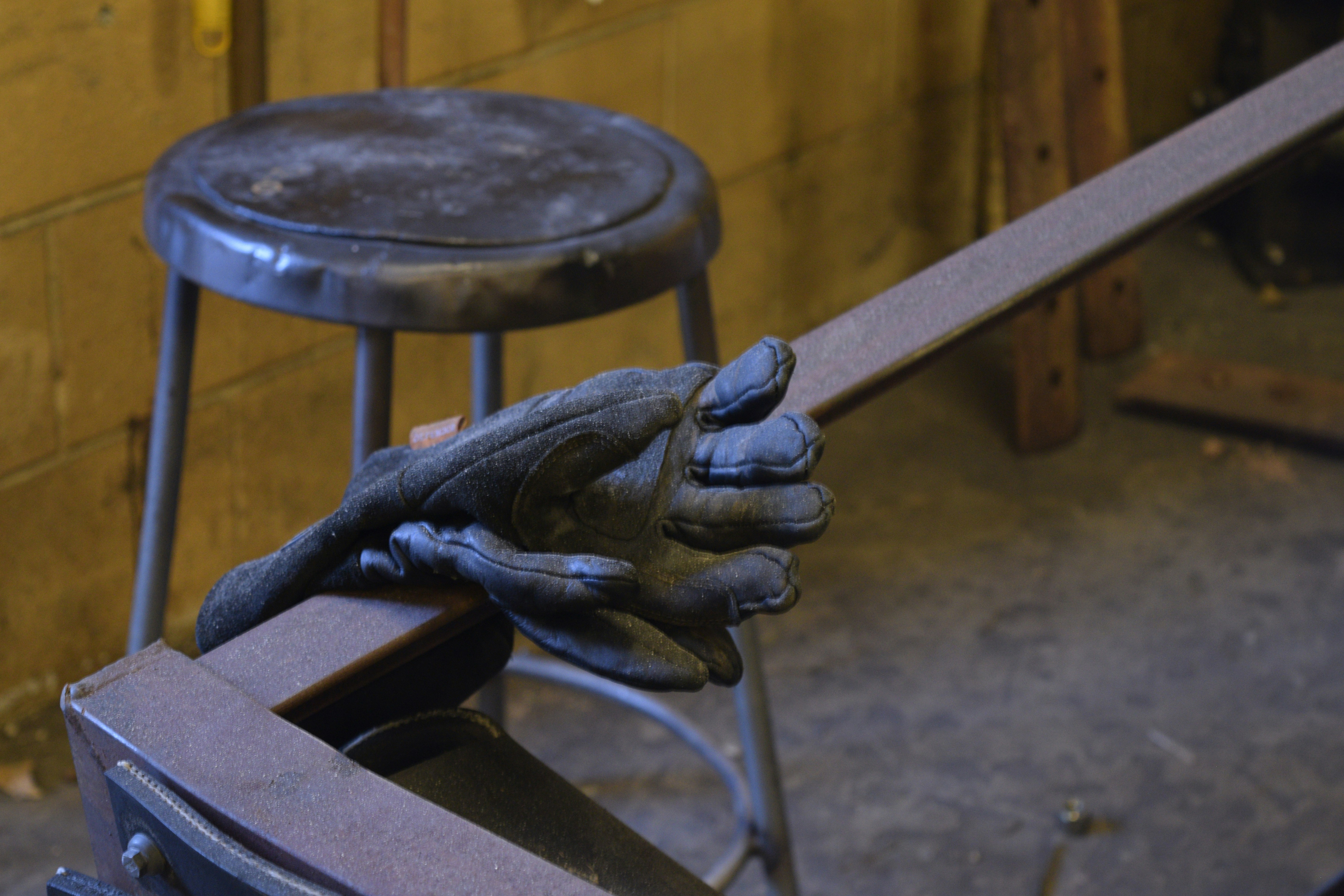 a pair of gloves sitting on top of a metal bench