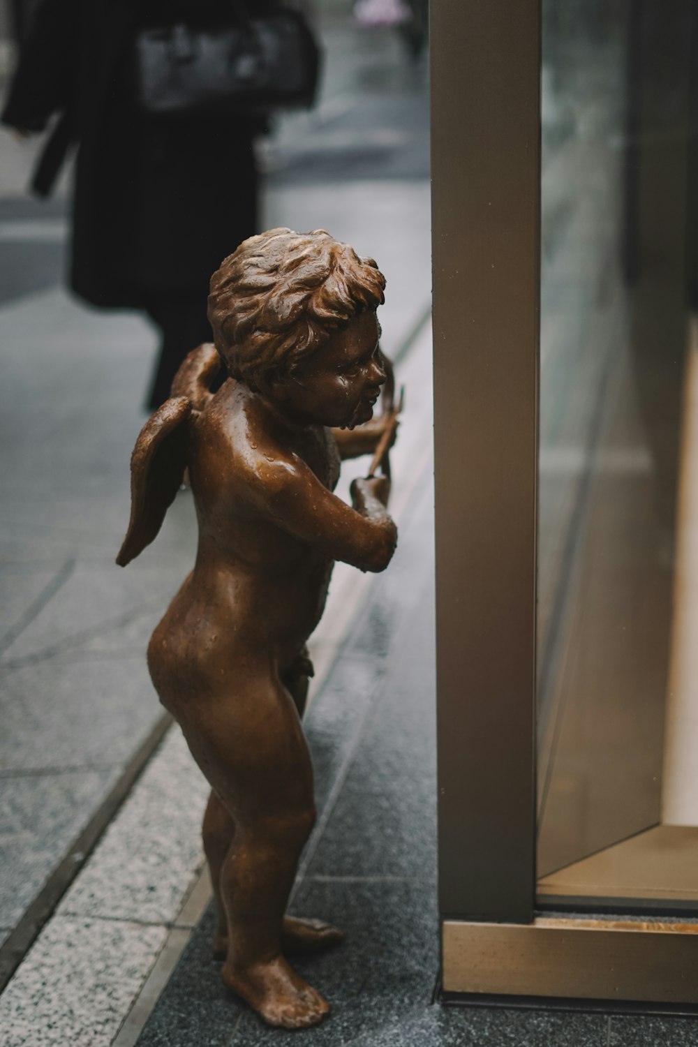 a bronze statue of a little girl on the sidewalk