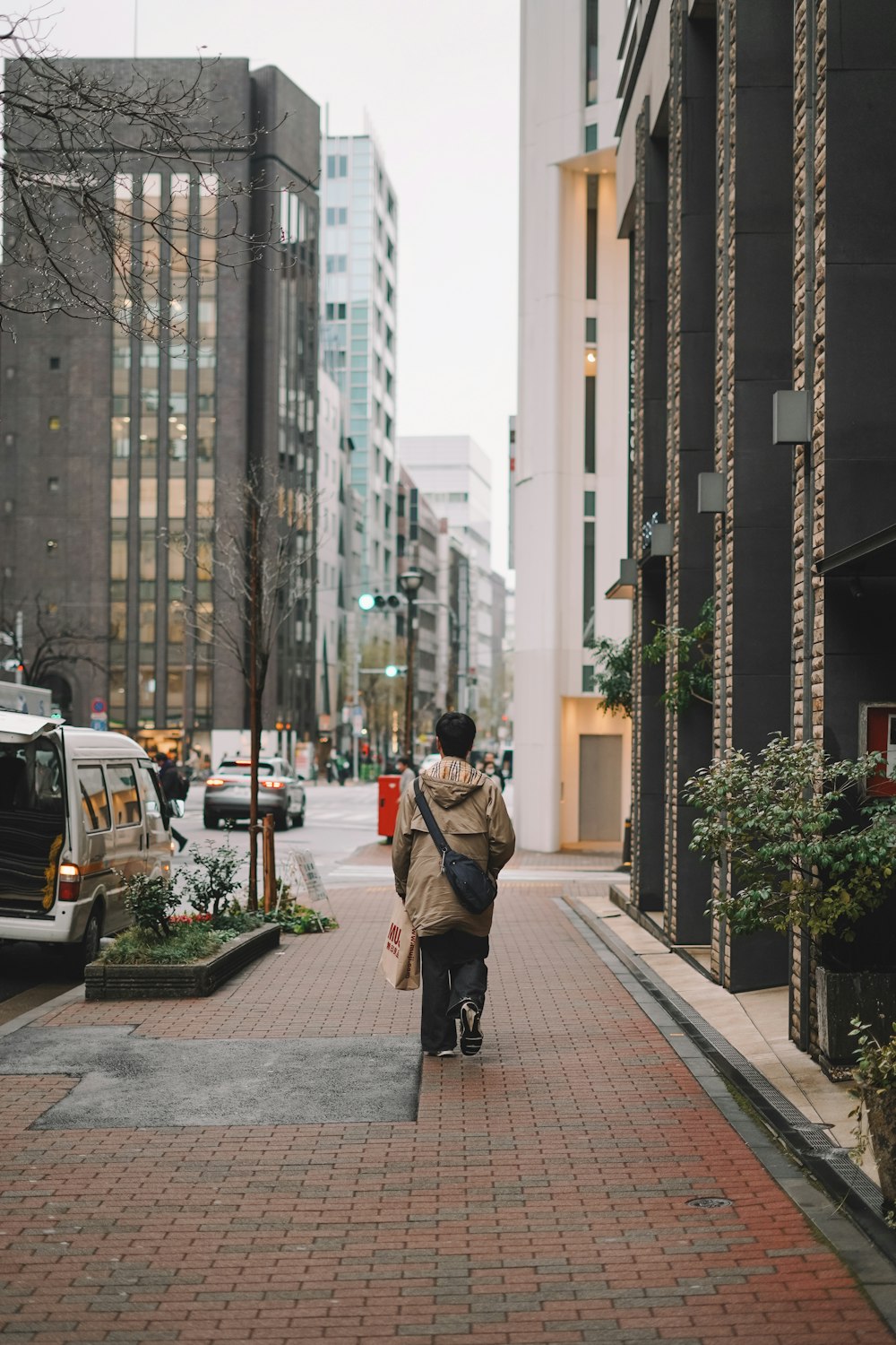 a woman walking down a sidewalk in a city