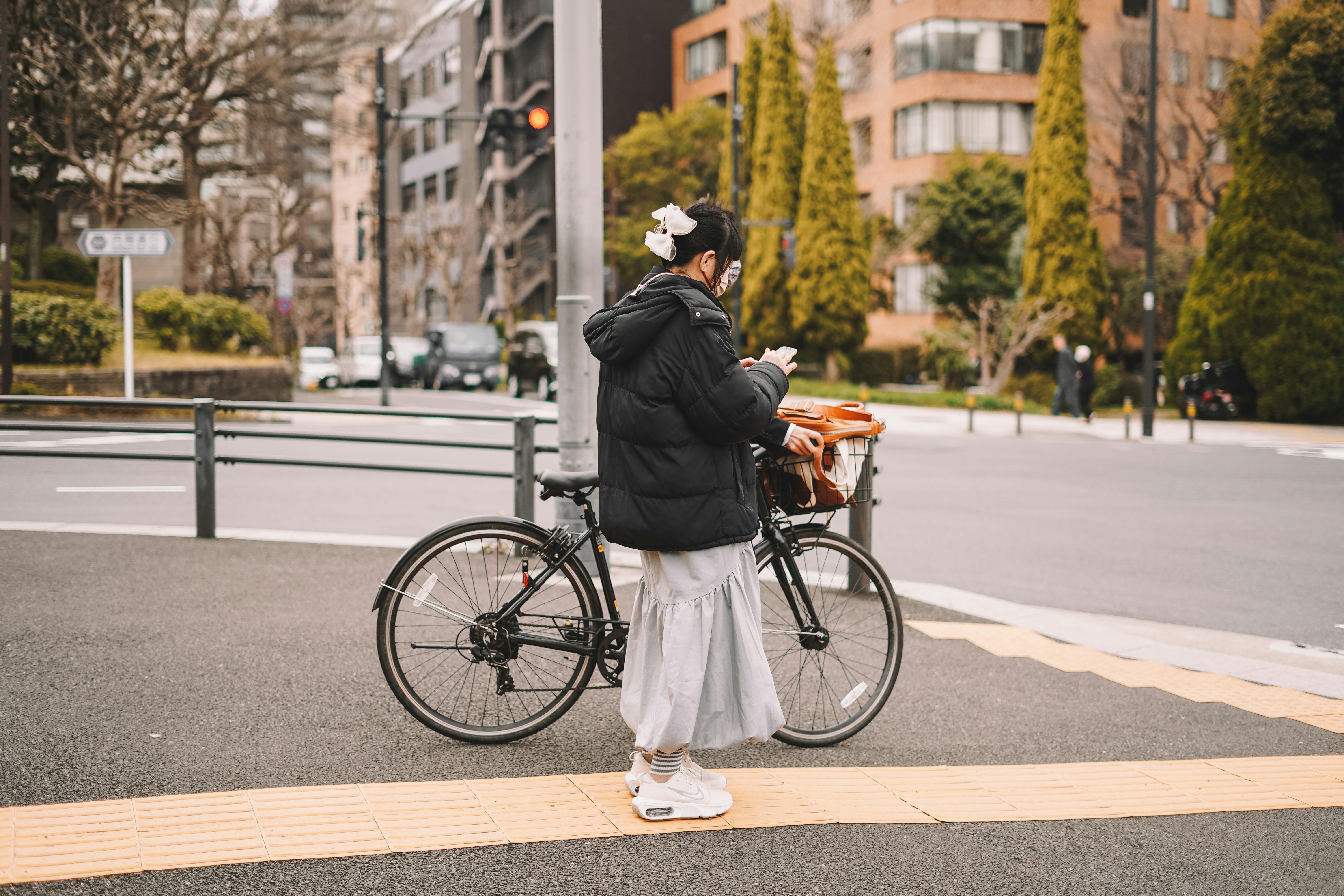 a person standing next to a bike on a street