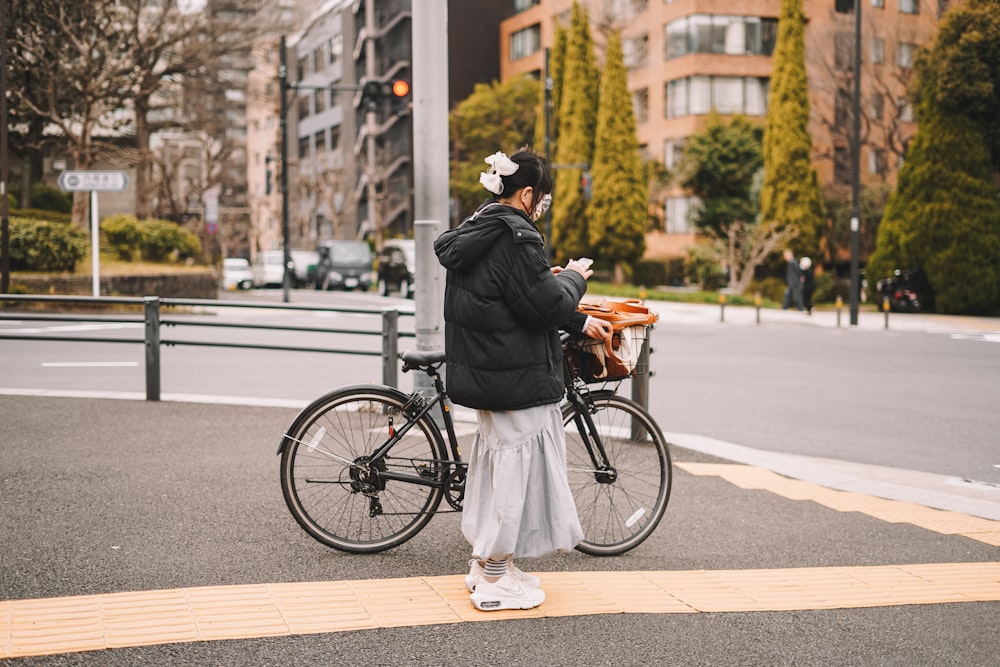 a person standing next to a bike on a street