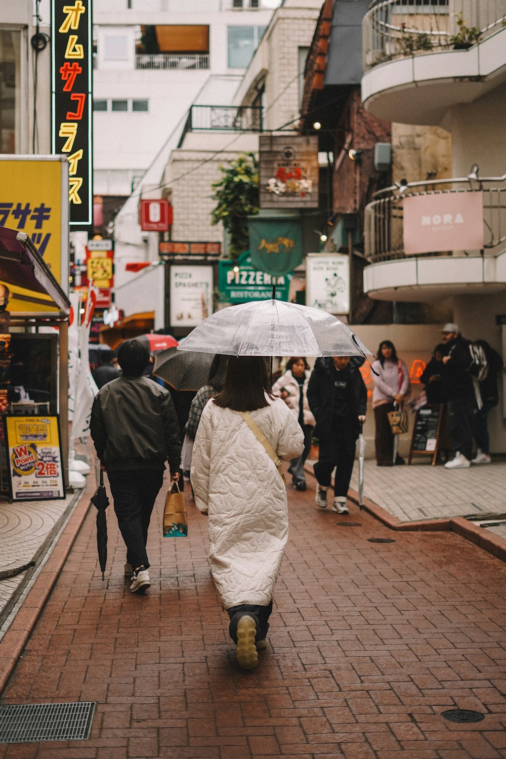 una donna che cammina lungo una strada con in mano un ombrello