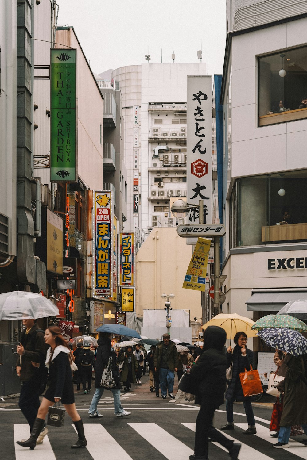 Eine Gruppe von Menschen, die mit Regenschirmen über eine Straße gehen