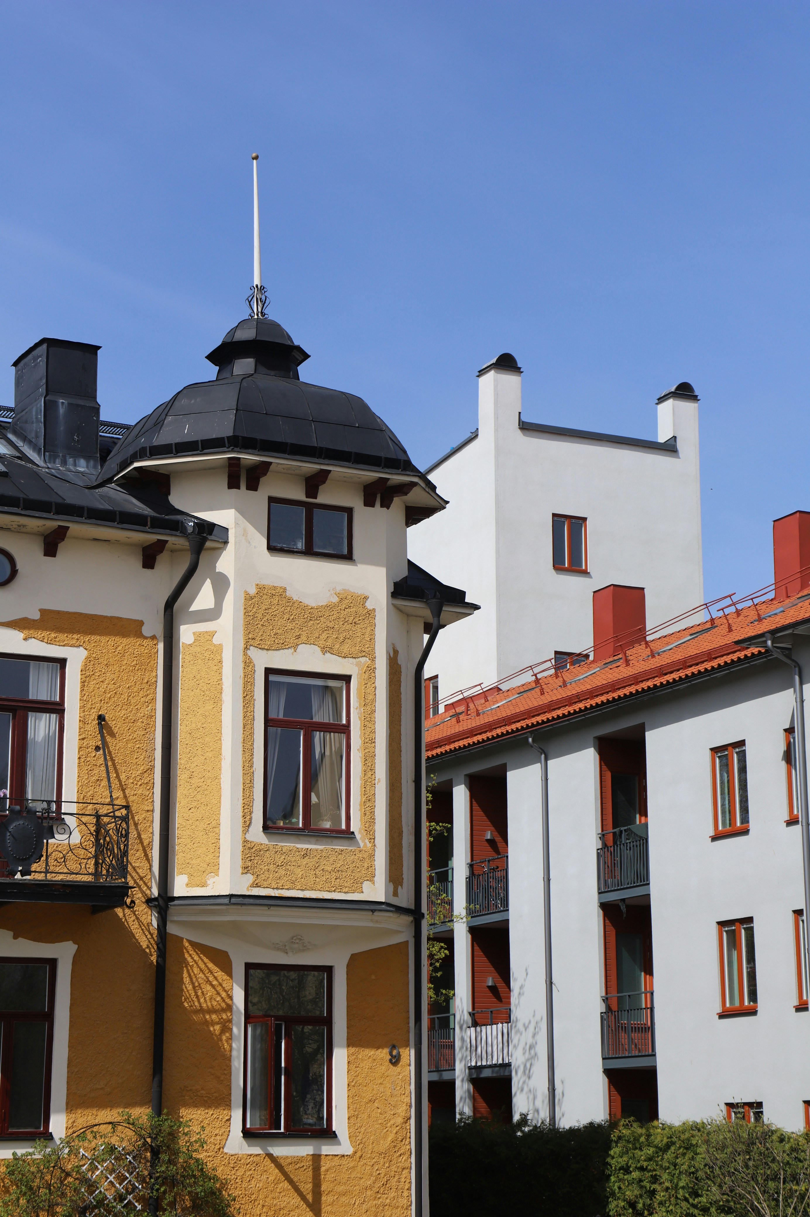 a yellow and white building with a black roof