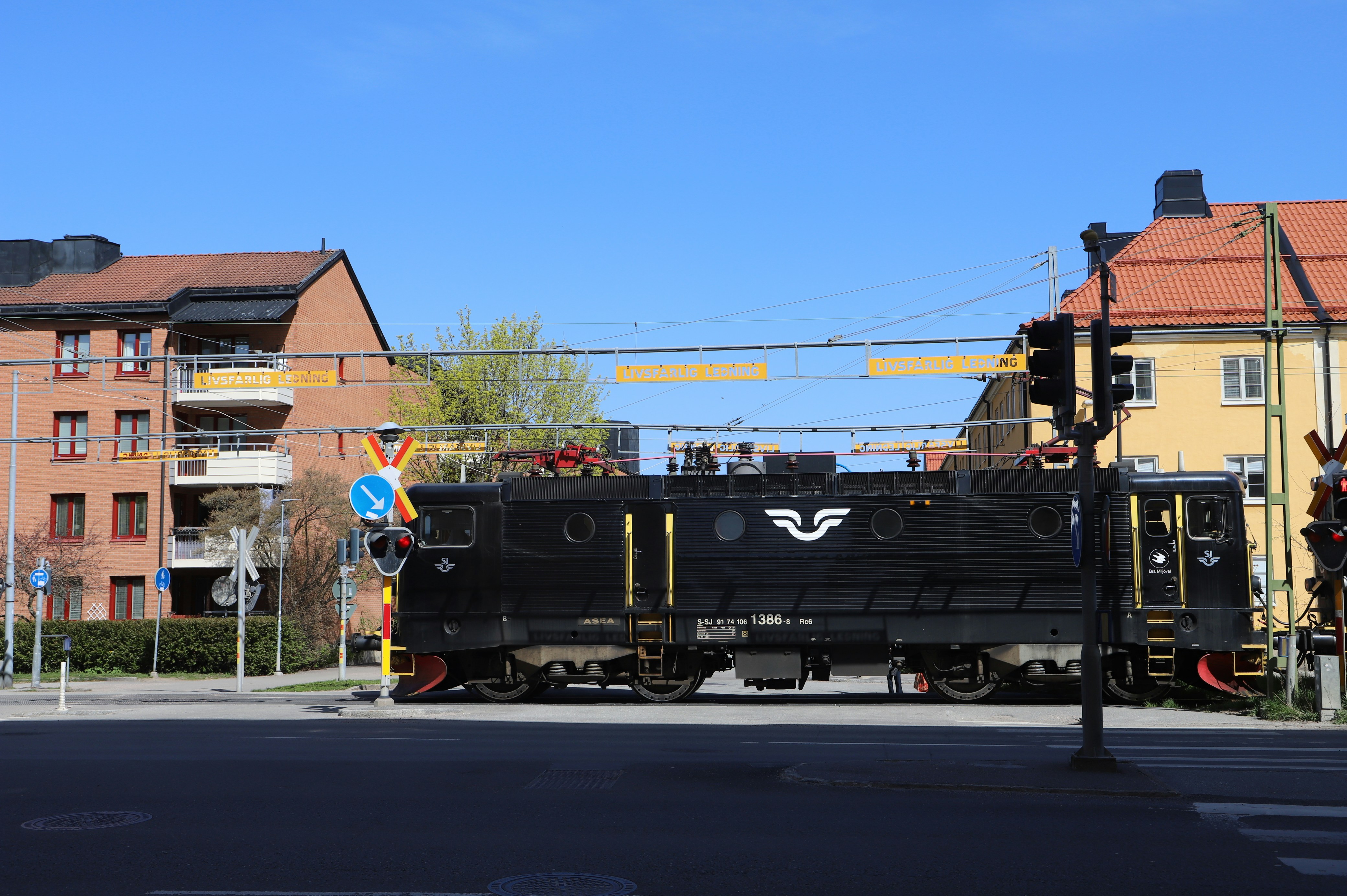 a black train traveling down train tracks next to tall buildings