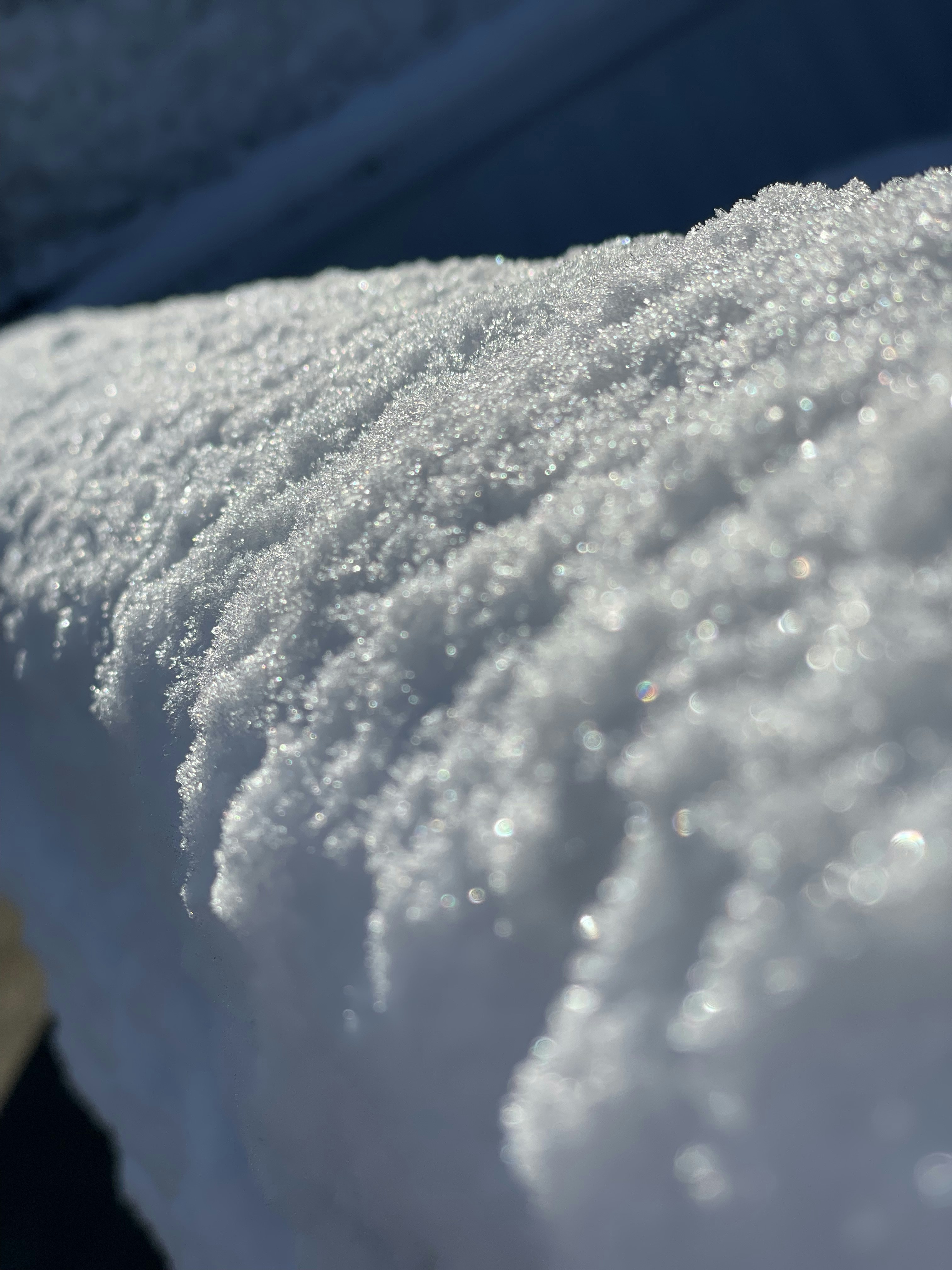 un primo piano di una panchina innevata