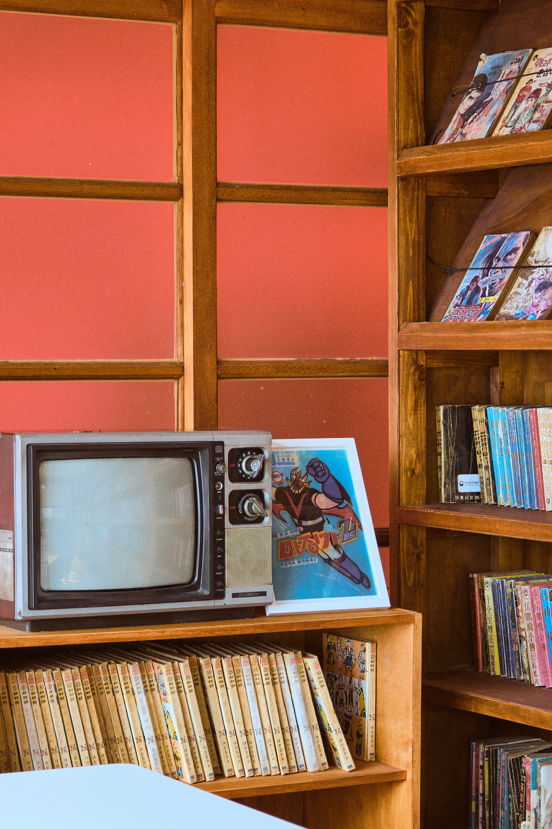 a television sitting on top of a wooden shelf