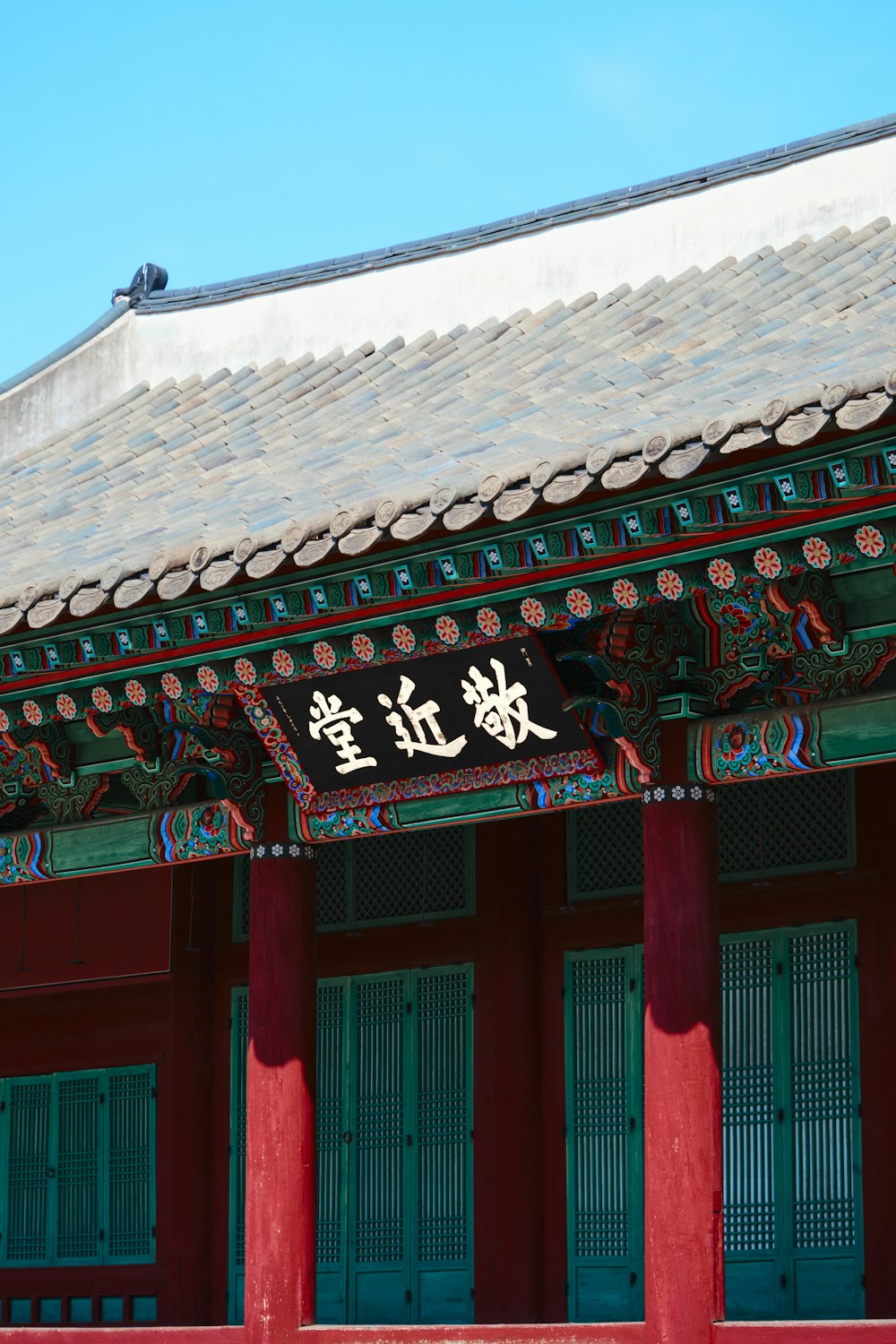 a chinese building with red pillars and a white roof