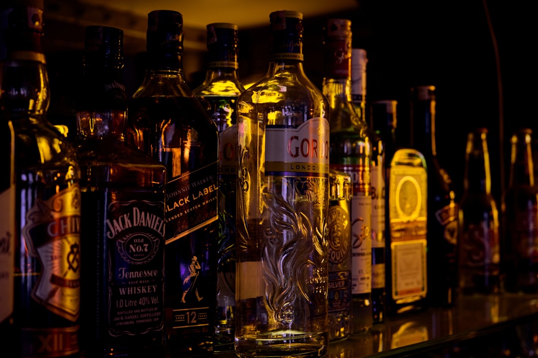 a row of liquor bottles sitting on top of a bar,