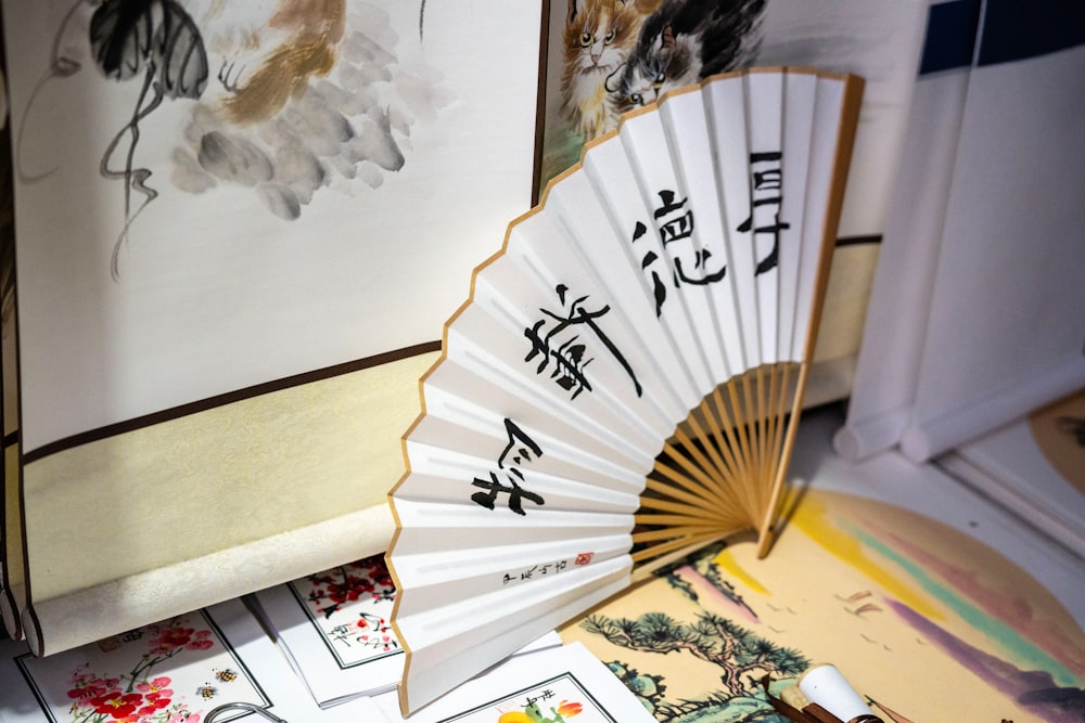 a white fan sitting on top of a table next to pictures