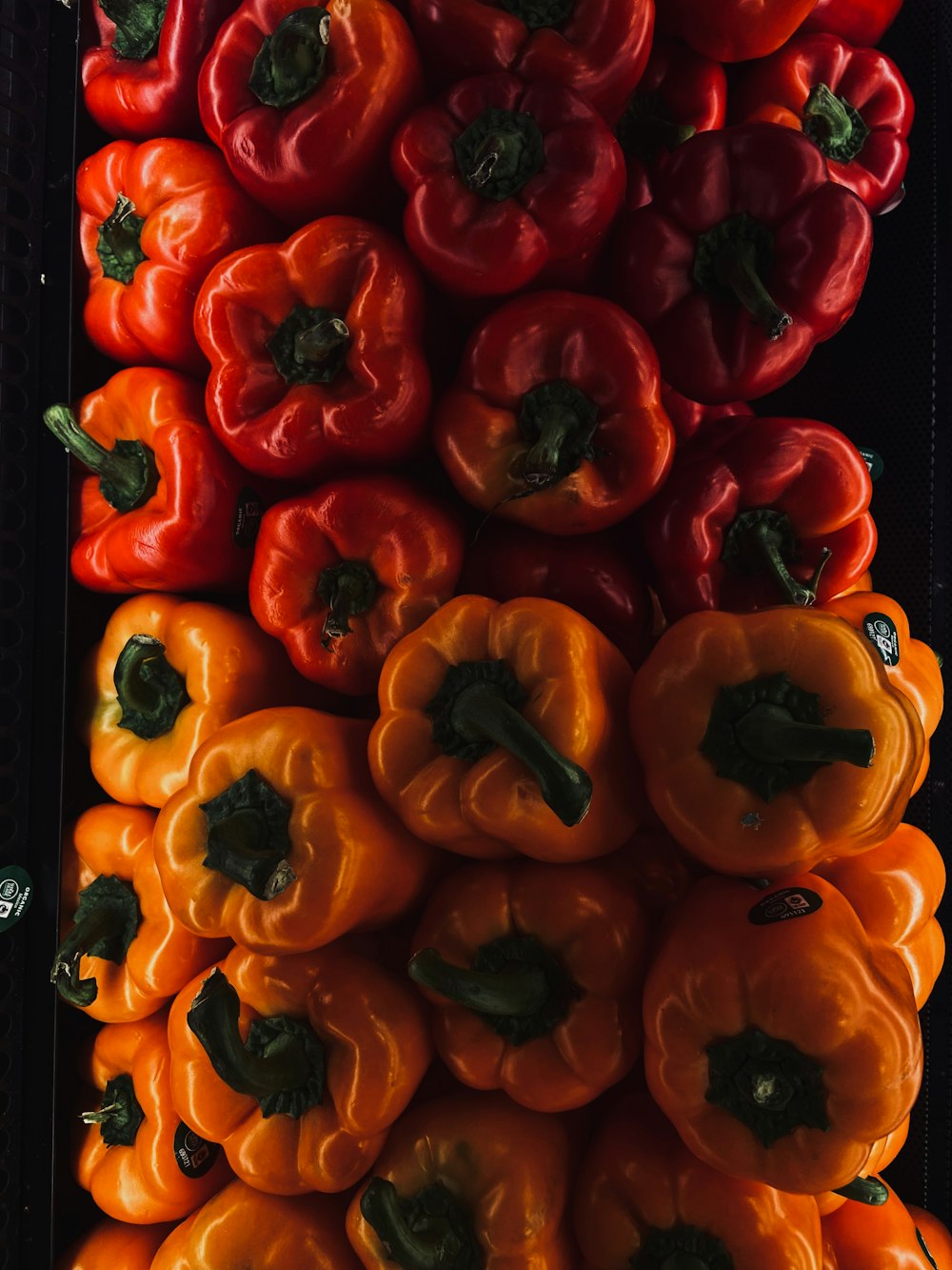 a pile of red and orange bell peppers