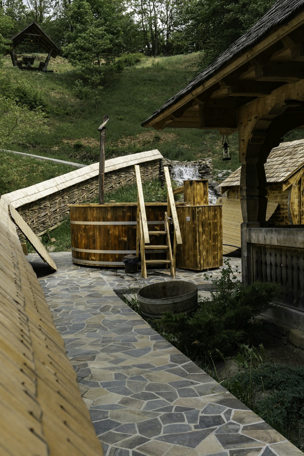 a wooden hot tub sitting next to a stone walkway