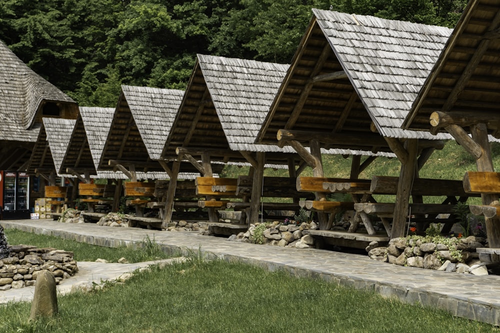 a row of wooden buildings sitting on top of a lush green field