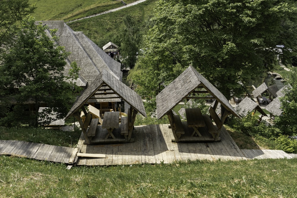 a couple of wooden structures sitting on top of a lush green hillside