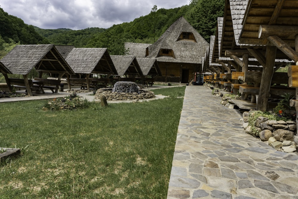 a row of wooden buildings sitting on top of a lush green hillside