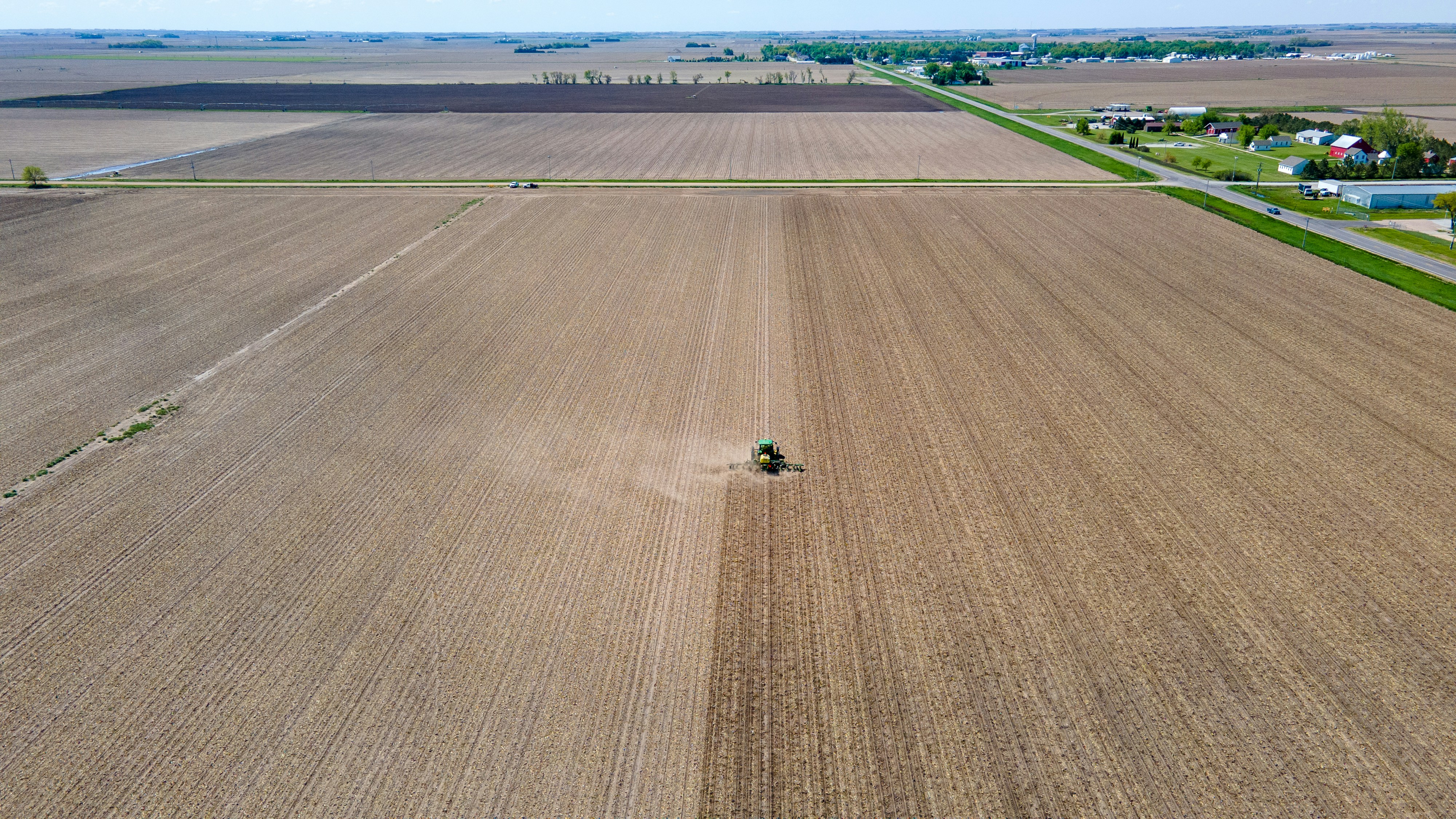 an aerial view of a farm with a tractor in the middle of the field