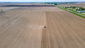 an aerial view of a farm with a tractor in the middle of the field
