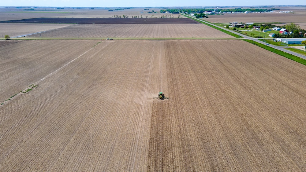 an aerial view of a farm with a tractor in the middle of the field