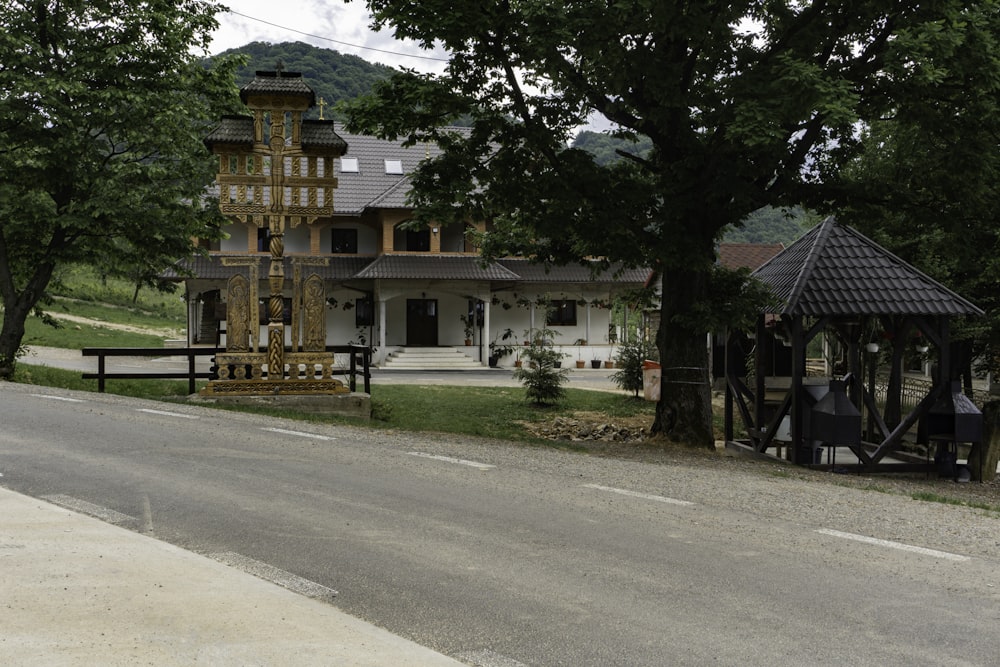 a large wooden clock tower sitting on the side of a road