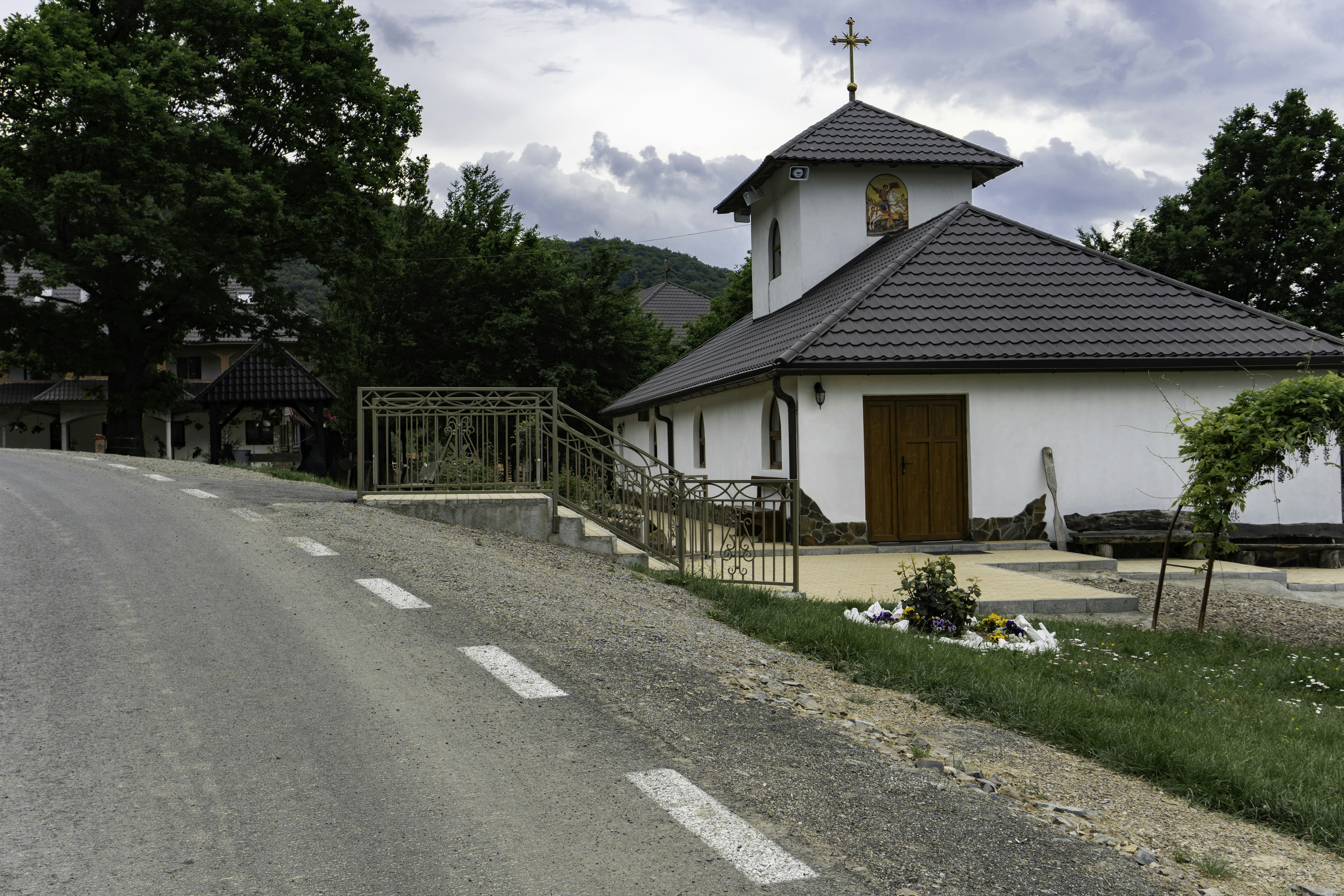 a church with a steeple and a steeple on the side of the road