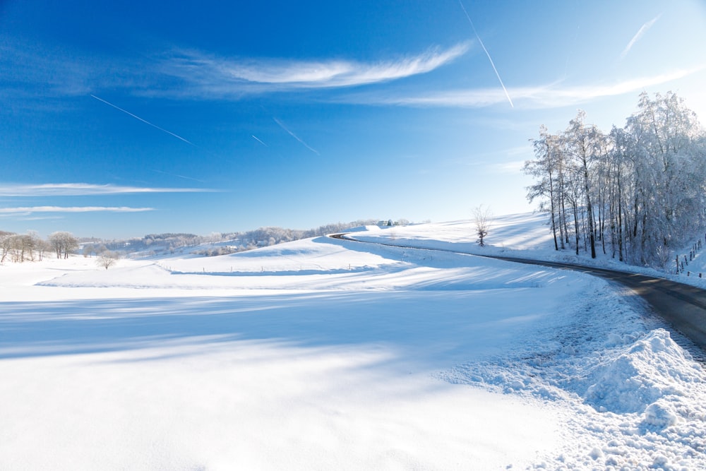 a road in the middle of a snow covered field