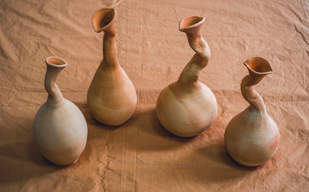 a group of three vases sitting on top of a table