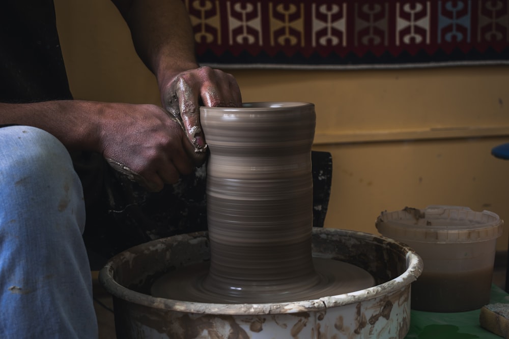 a person making a vase on a potter's wheel