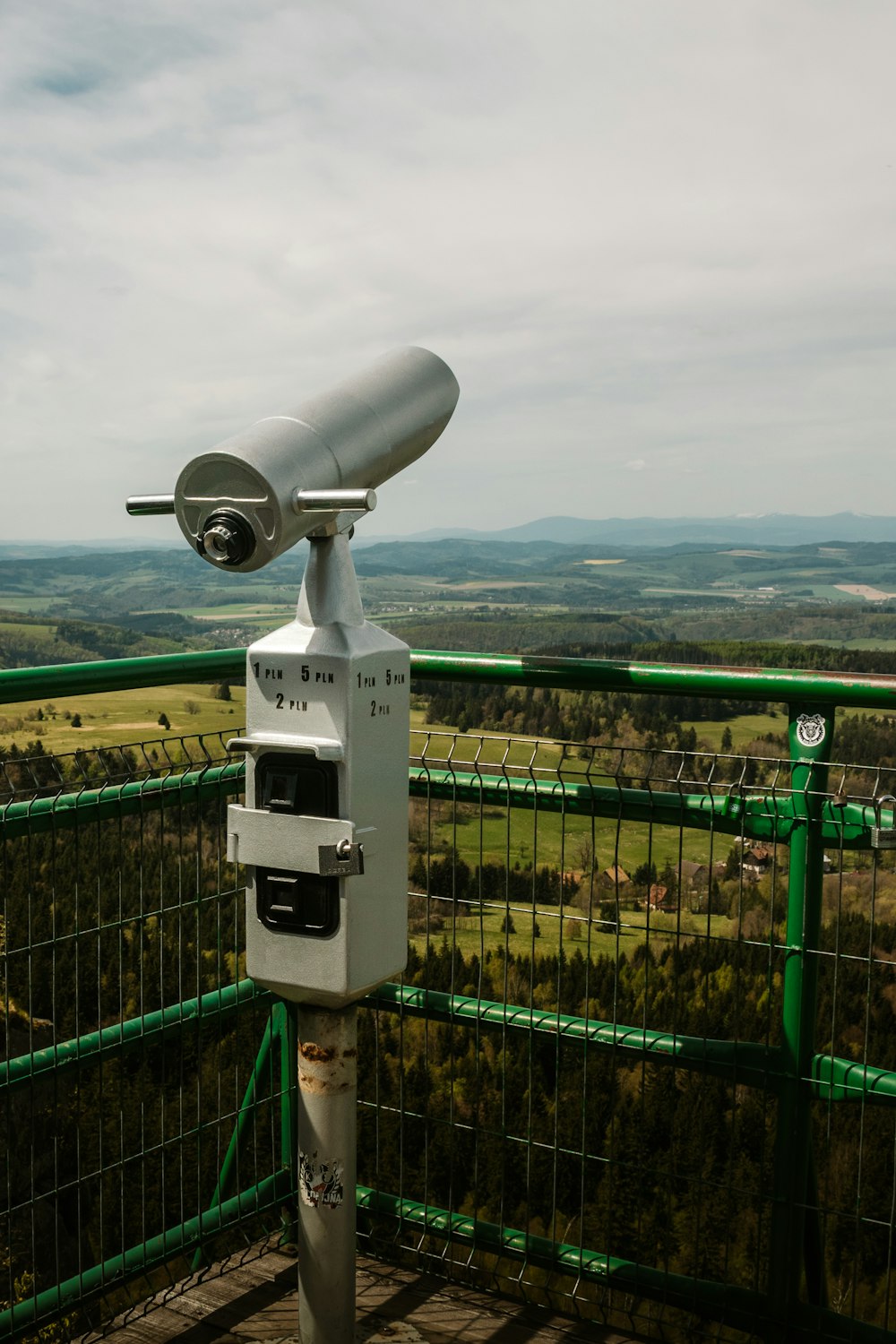 a telescope on top of a green fence