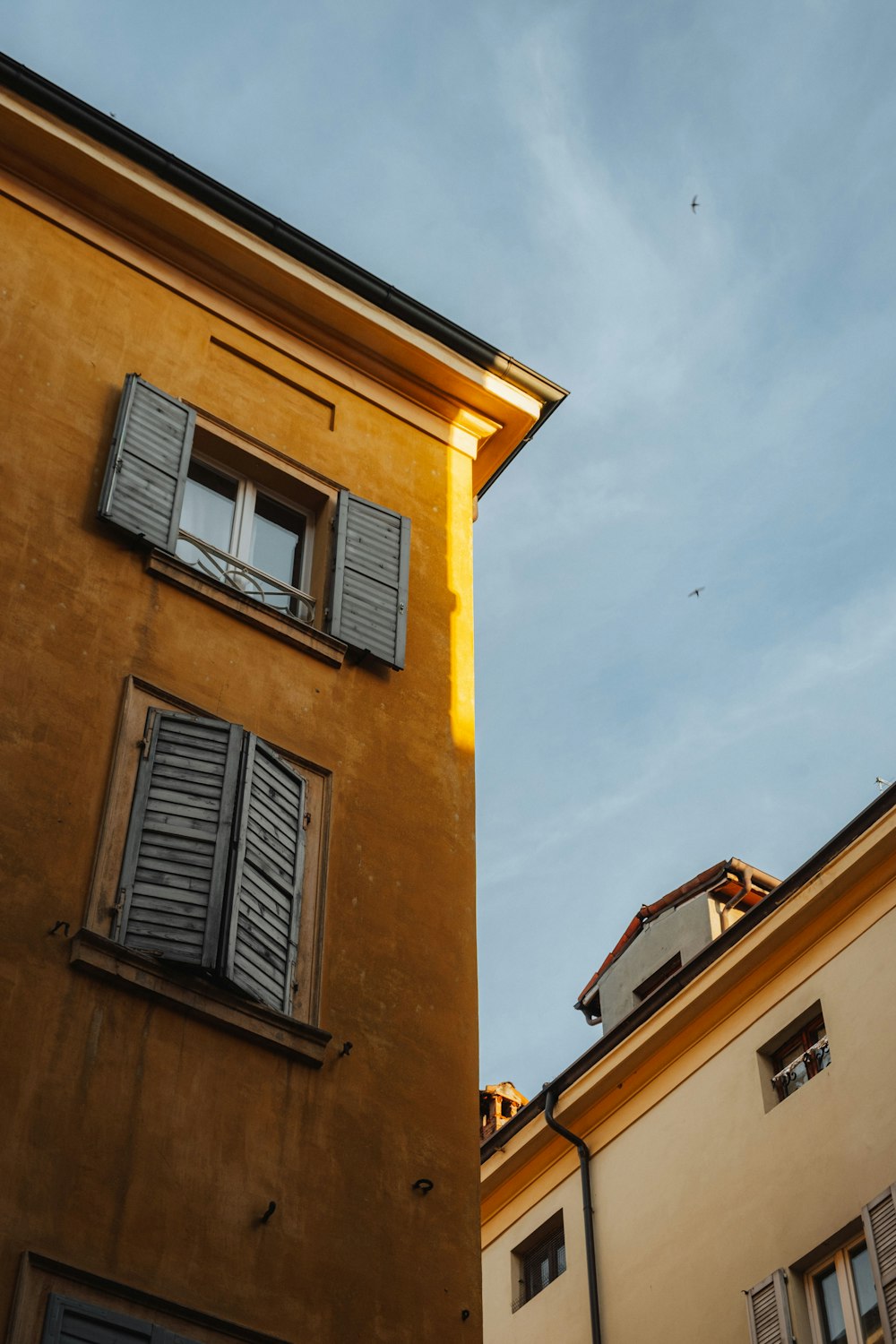 a tall building with shutters on the windows