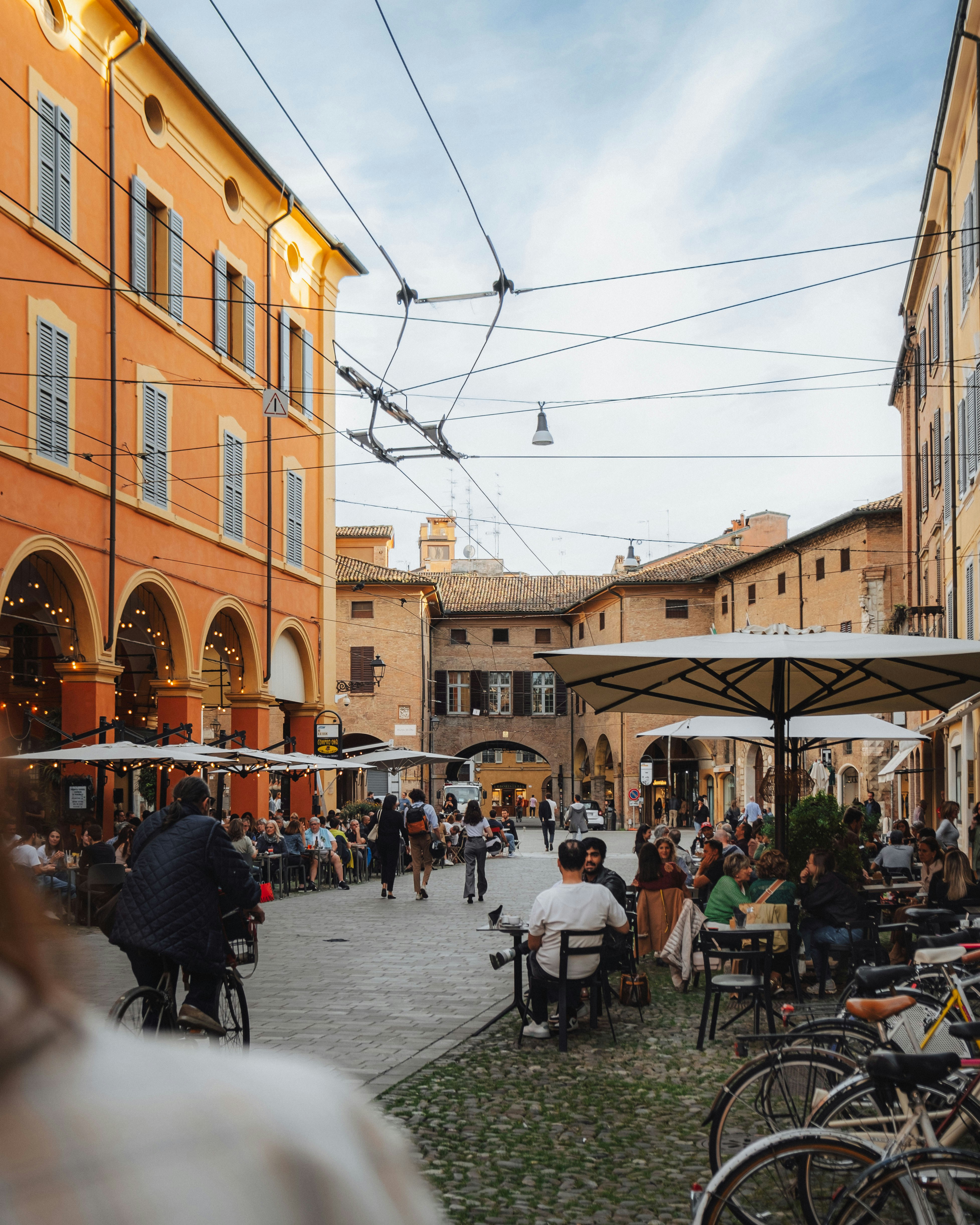 a group of people sitting at tables in a courtyard
