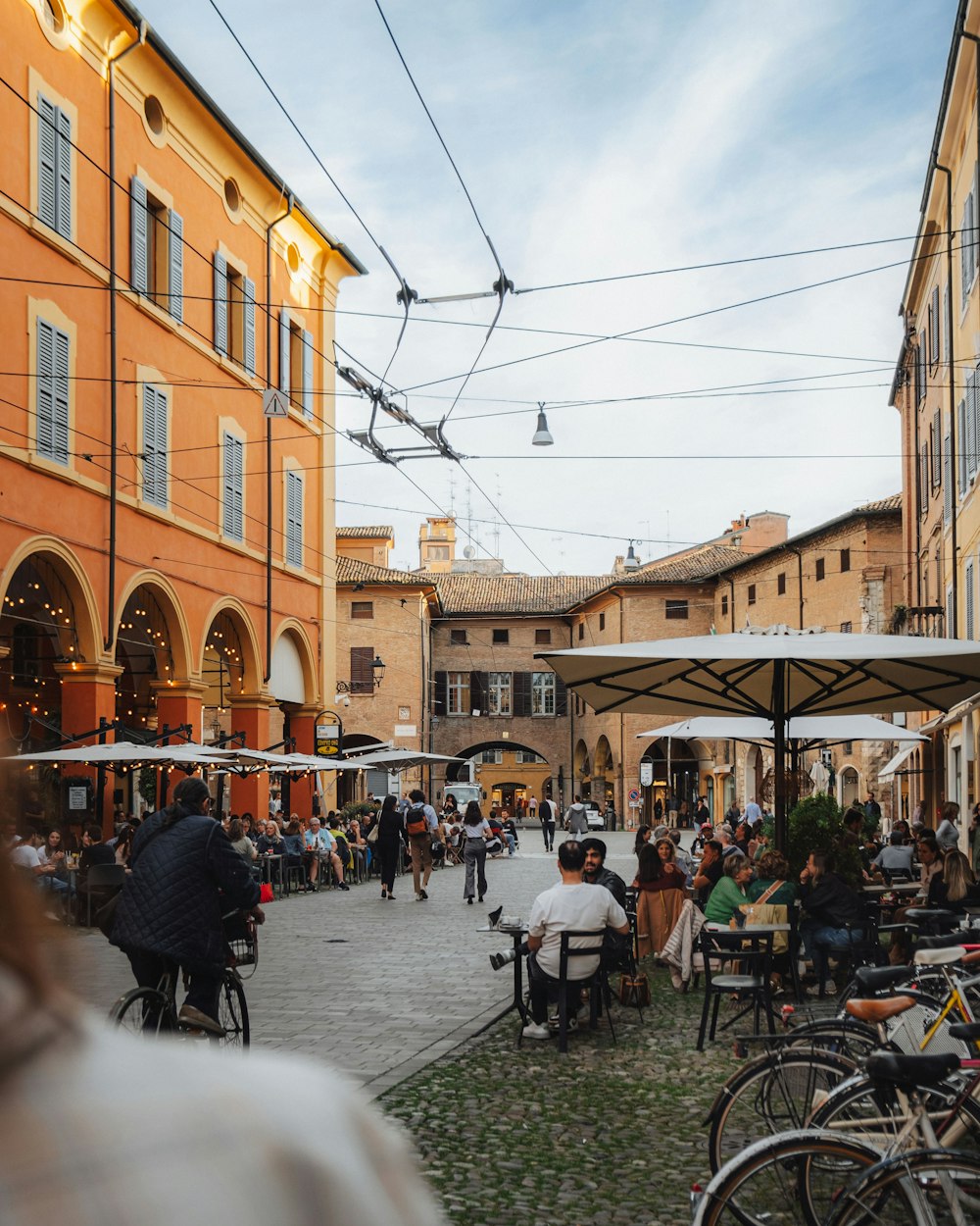 a group of people sitting at tables in a courtyard