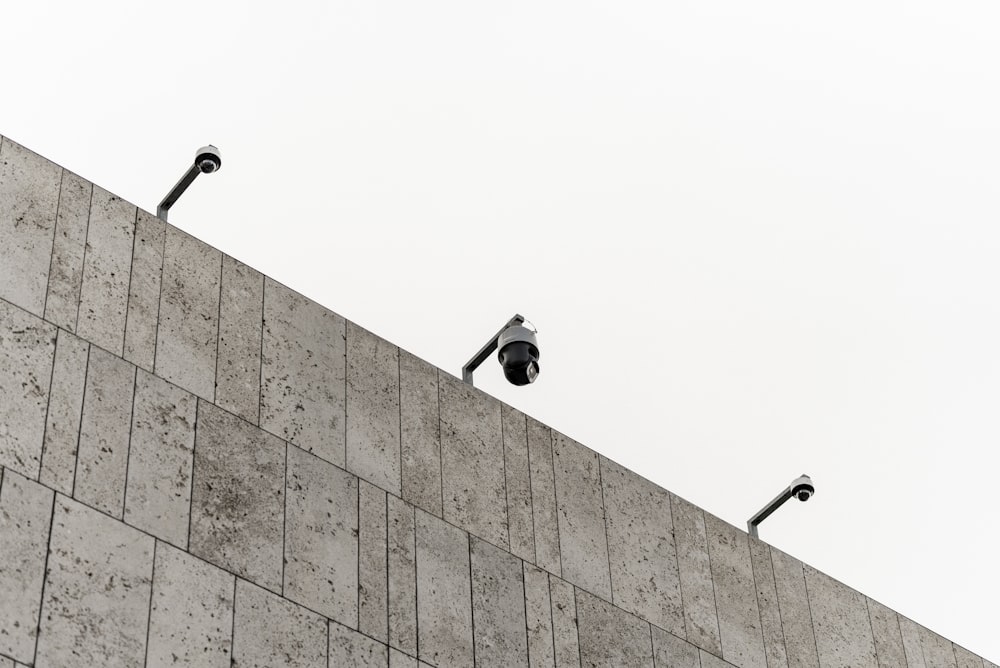 a couple of cameras sitting on top of a wall