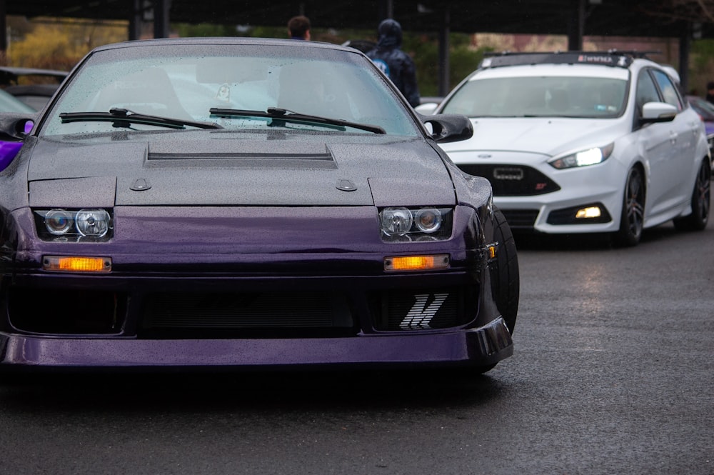 a purple car parked in a parking lot next to other cars