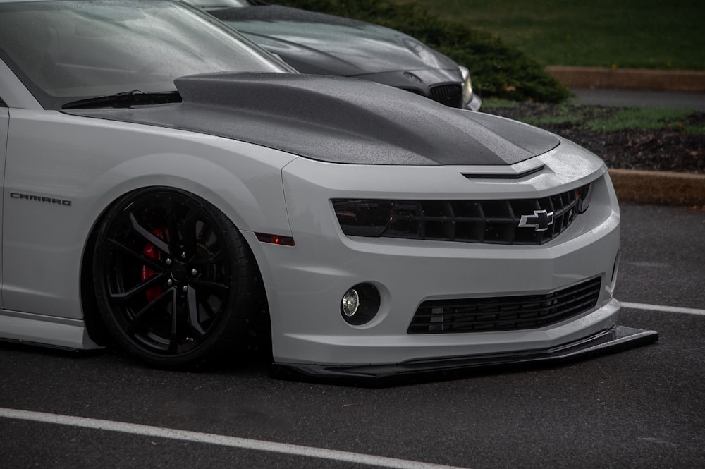 a white chevrolet camaro parked in a parking lot
