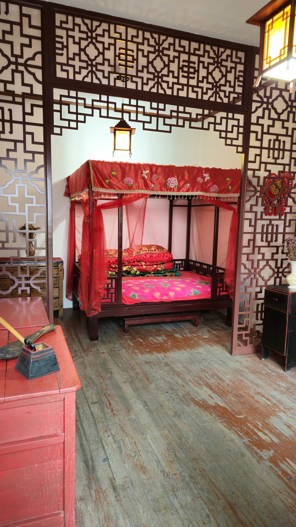 a room with a bed, dresser and lamp