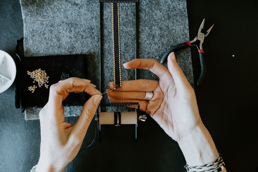 a woman is working on a piece of jewelry