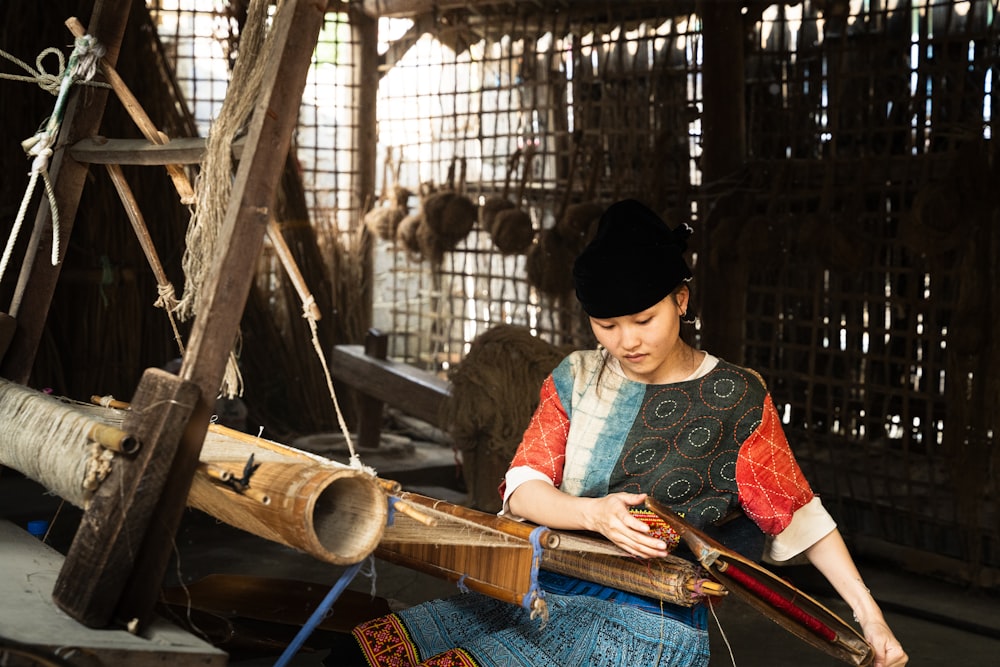 a woman is working on a weaving machine