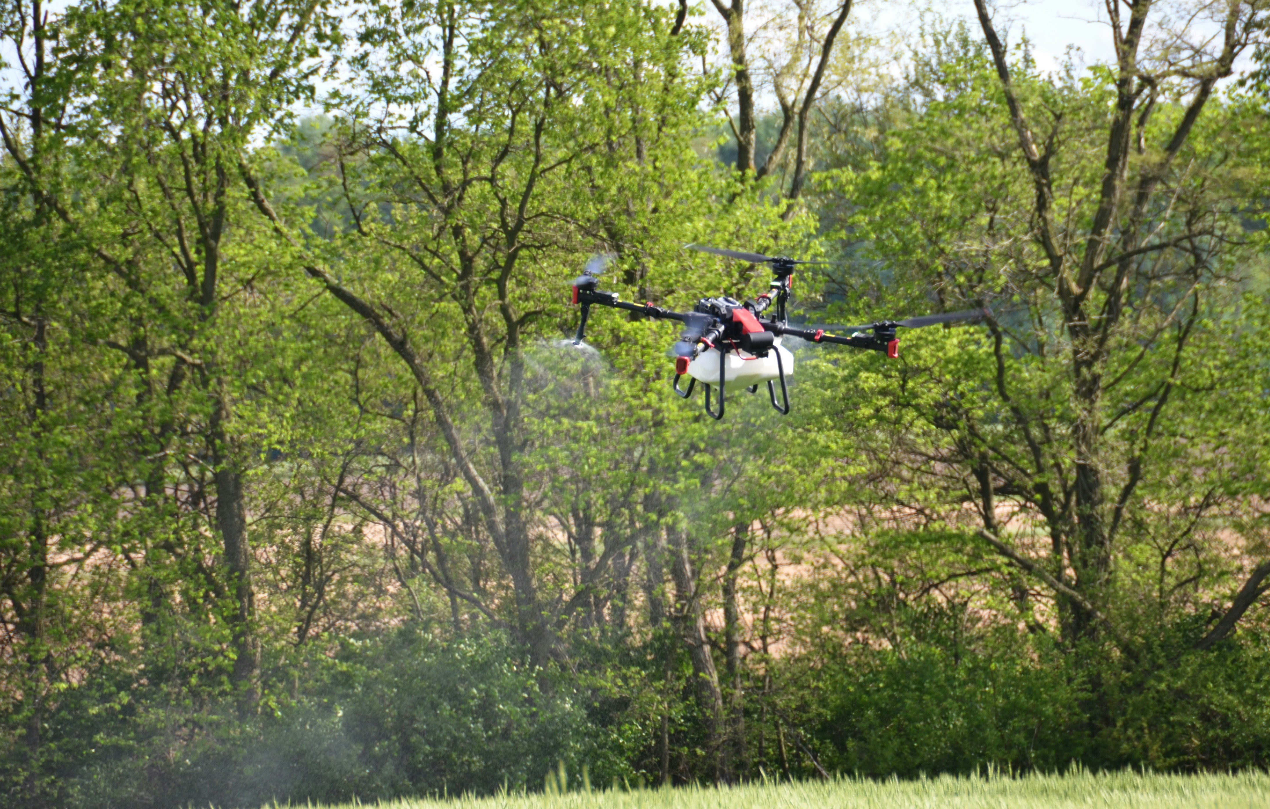 a helicopter flying over a lush green forest