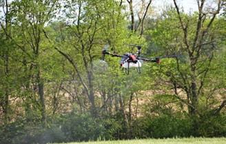 a helicopter flying over a lush green forest