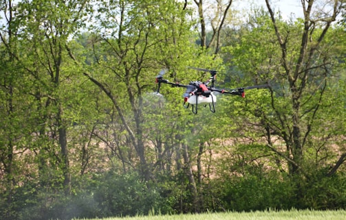 a helicopter flying over a lush green forest